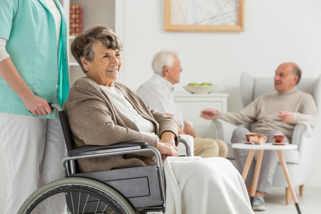 Healthcare worker with elderly woman in wheelchair at care facility